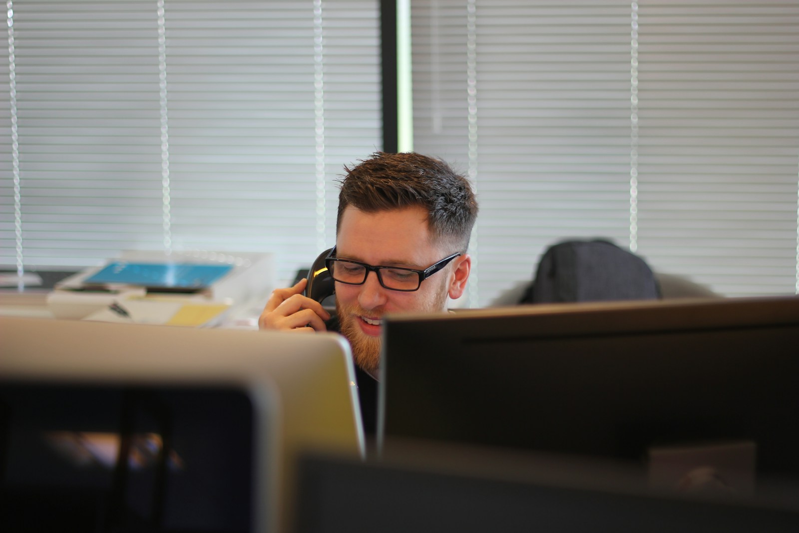 homme utilisant un téléphone IP dans une pièce